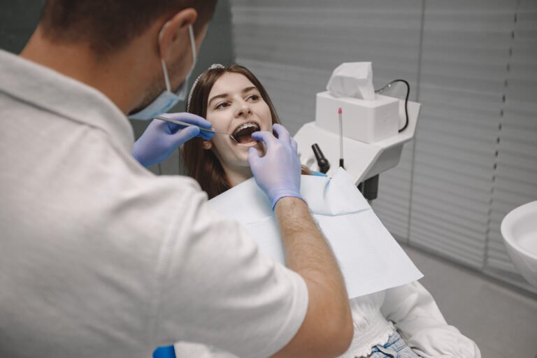 Dentist examining a patient for dentures near Long Beach, California, at Art Family Dental